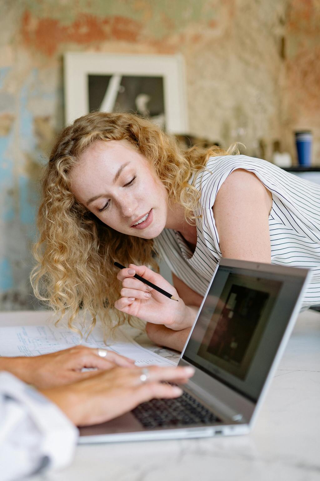 Lady leaning over a computer