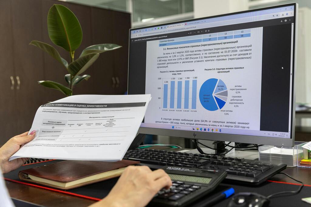 Person sitting at computer with financial analysis on screen